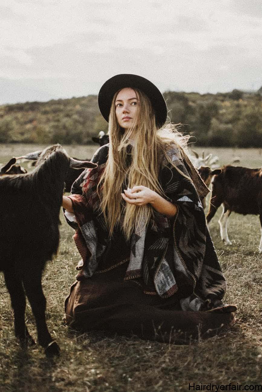 mujer con sombrero entre cabras