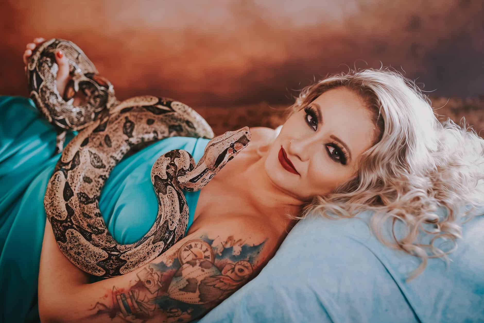 photo of a woman with a tattoo posing with a python