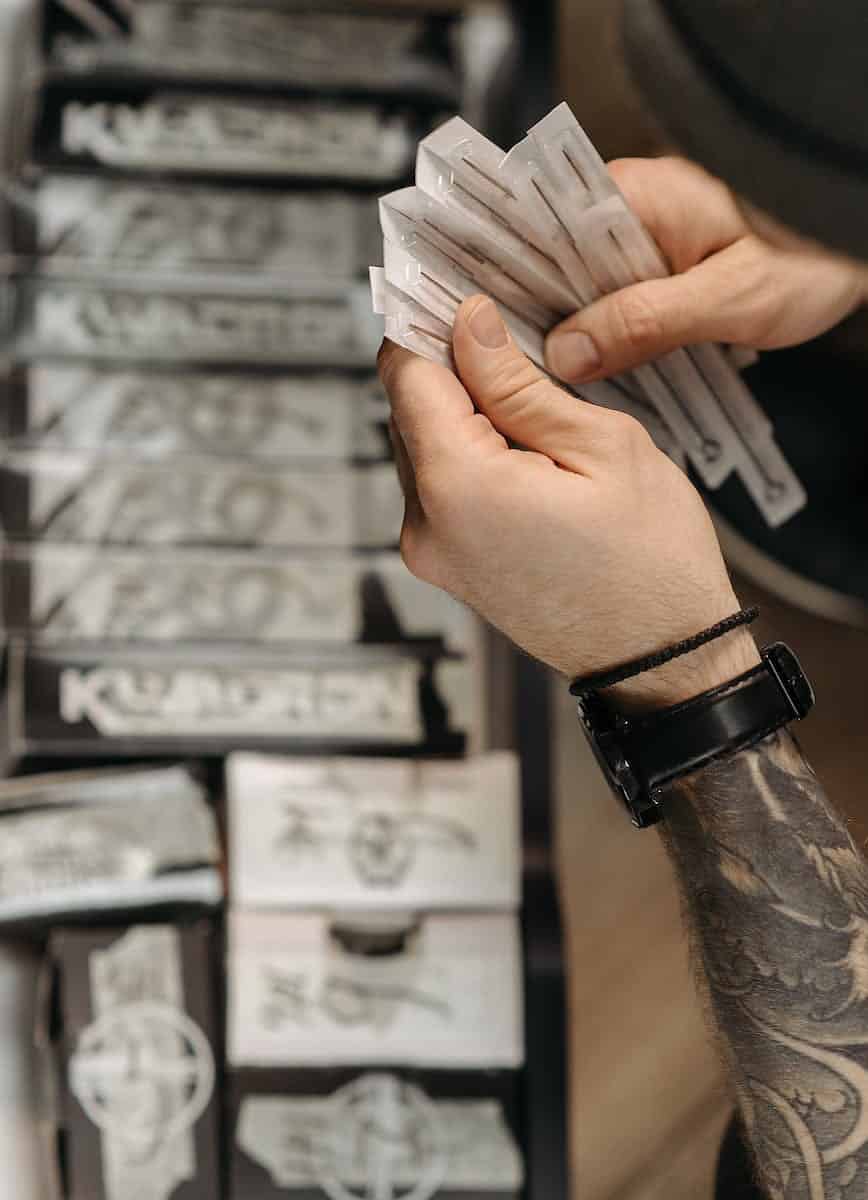 close up shot of a person holding tattoo needles